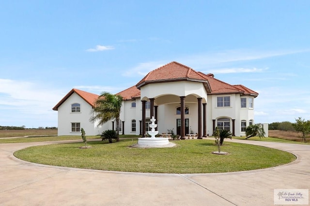 mediterranean / spanish home featuring a front lawn