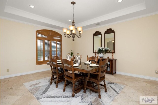 dining area featuring ornamental molding, a raised ceiling, and a notable chandelier