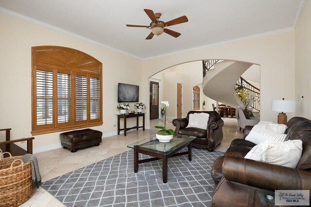 tiled living room with ceiling fan and crown molding