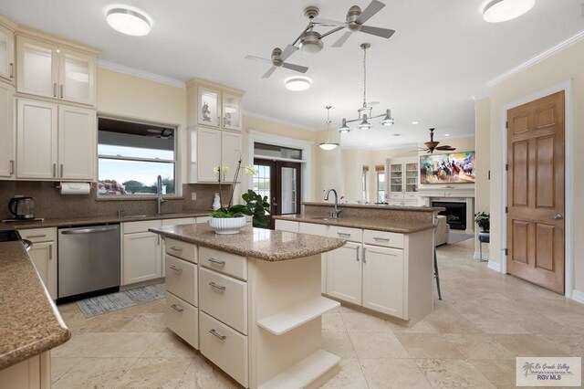 kitchen with stainless steel dishwasher, a kitchen island, hanging light fixtures, and tasteful backsplash