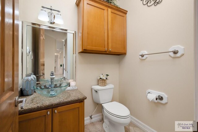 bathroom with tile patterned flooring, vanity, and toilet