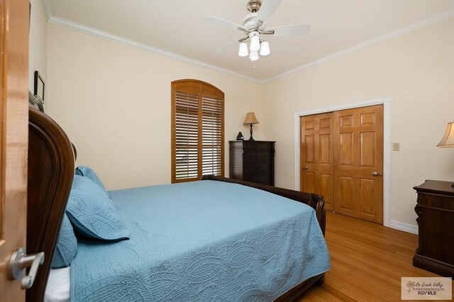 bedroom featuring a closet, light hardwood / wood-style floors, ceiling fan, and ornamental molding