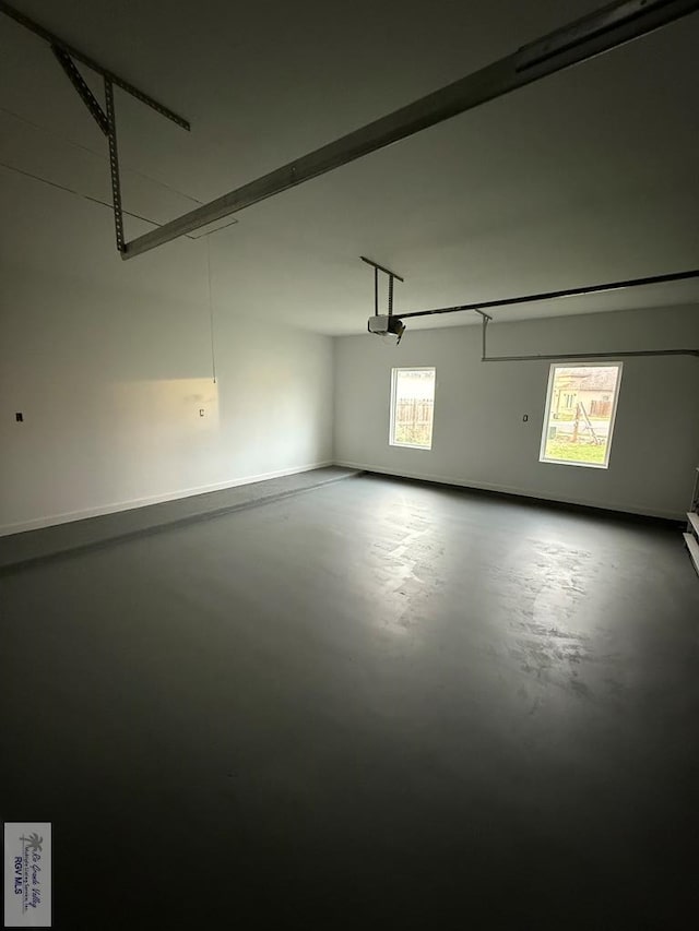 garage with baseboards and a garage door opener