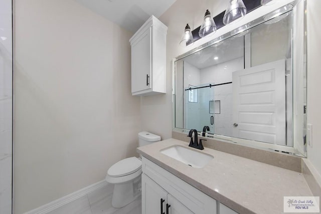 bathroom featuring baseboards, a shower stall, toilet, and vanity