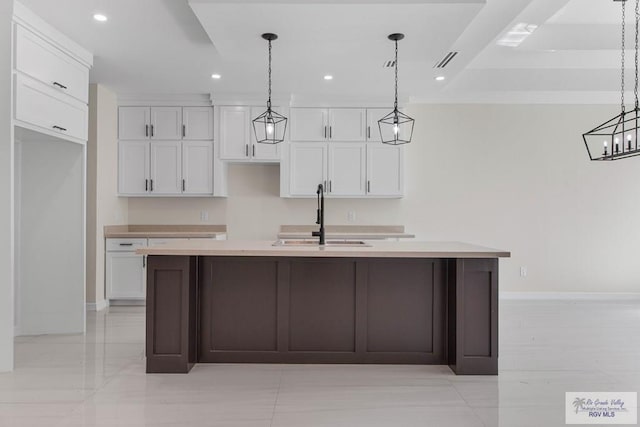 kitchen featuring recessed lighting, a sink, a center island with sink, and white cabinets