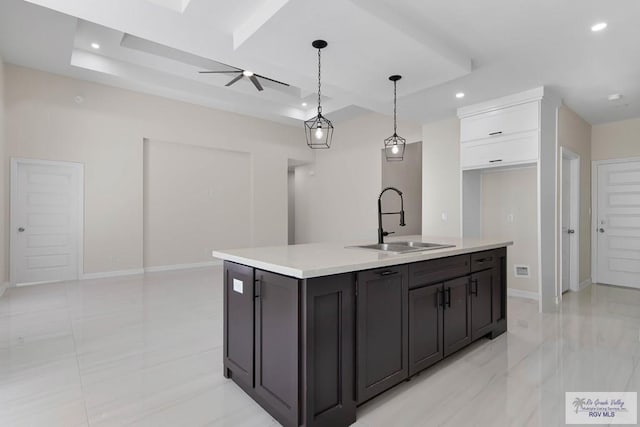 kitchen with light countertops, a tray ceiling, a sink, and recessed lighting