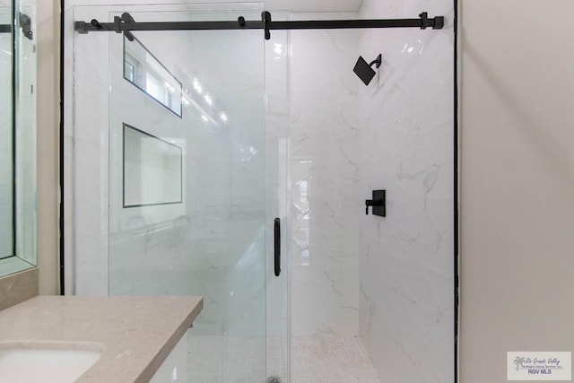 full bath with a marble finish shower and vanity