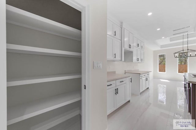 kitchen with a tray ceiling, open shelves, recessed lighting, light countertops, and white cabinetry