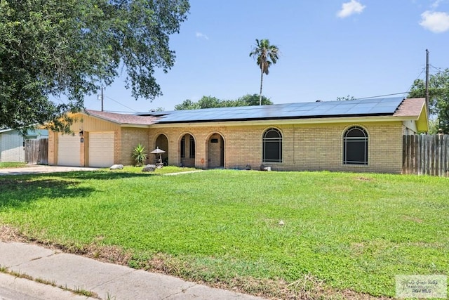 ranch-style home featuring solar panels, brick siding, and a garage