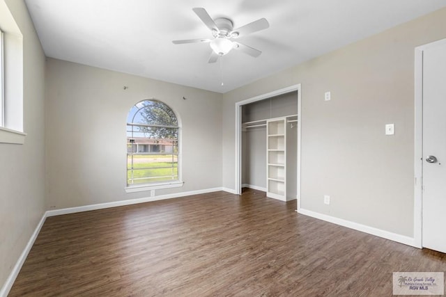 unfurnished bedroom with wood finished floors, a closet, baseboards, and ceiling fan