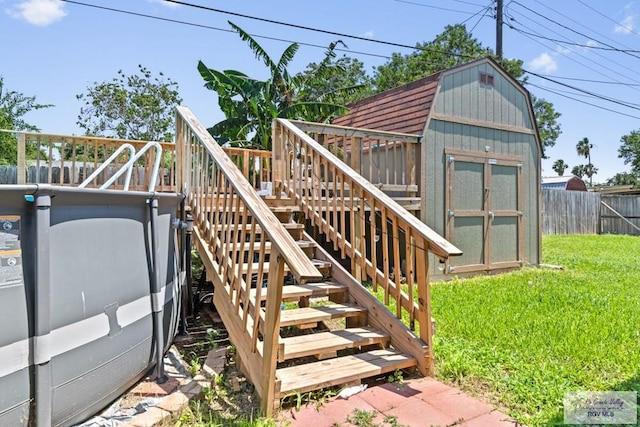 deck with stairway, a storage shed, and an outbuilding