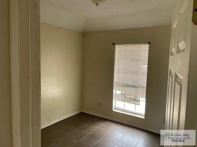 unfurnished room featuring tile patterned flooring and a textured ceiling