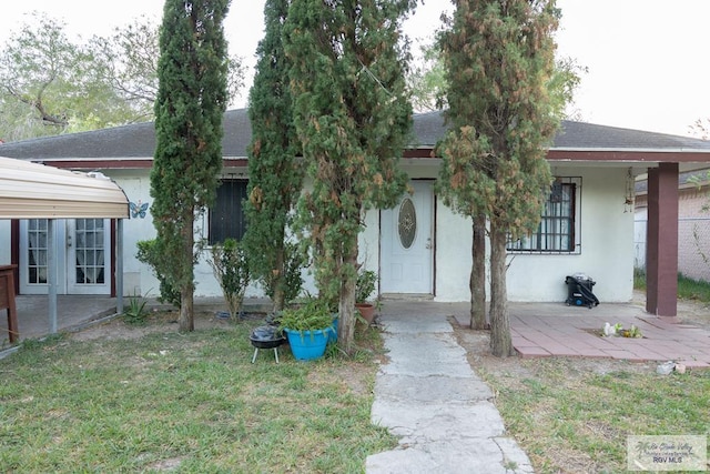 view of front facade featuring french doors, a front lawn, and a patio area