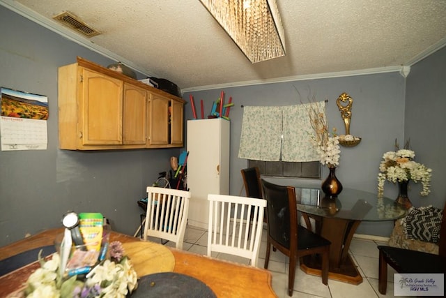 tiled dining area with a textured ceiling, crown molding, and a skylight