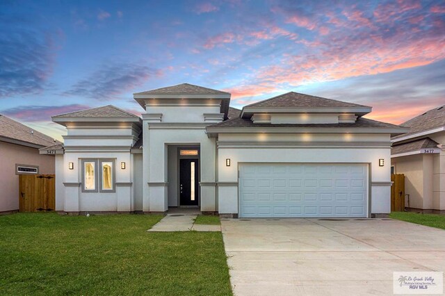 prairie-style house featuring a yard and a garage