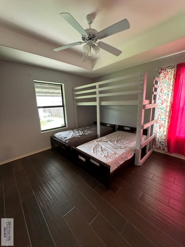 unfurnished bedroom featuring ceiling fan and dark wood-type flooring