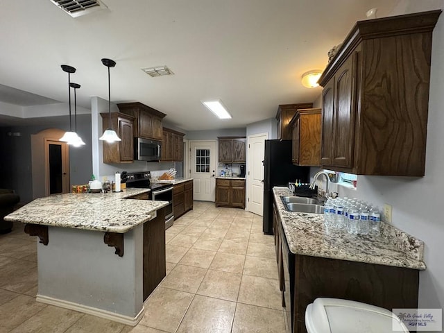 kitchen featuring stainless steel appliances, kitchen peninsula, decorative light fixtures, a kitchen bar, and dark brown cabinets