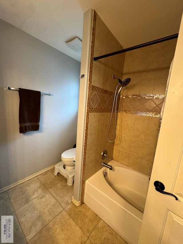 bathroom with tile patterned floors, tiled shower / bath, and toilet