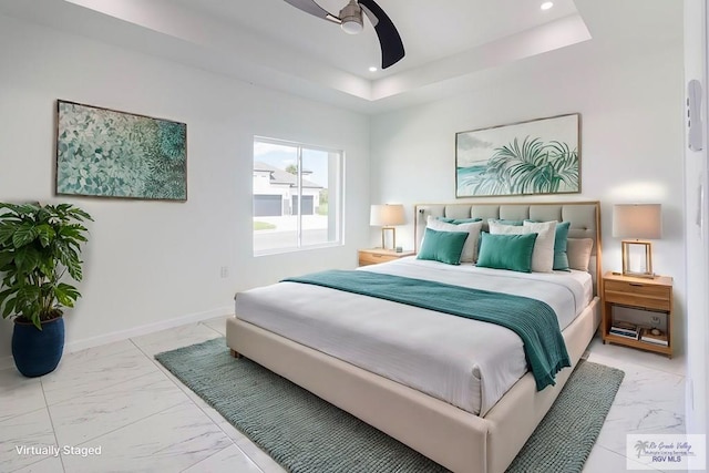 bedroom featuring ceiling fan and a raised ceiling