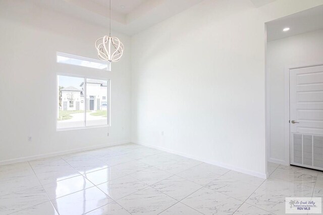 spare room featuring a chandelier