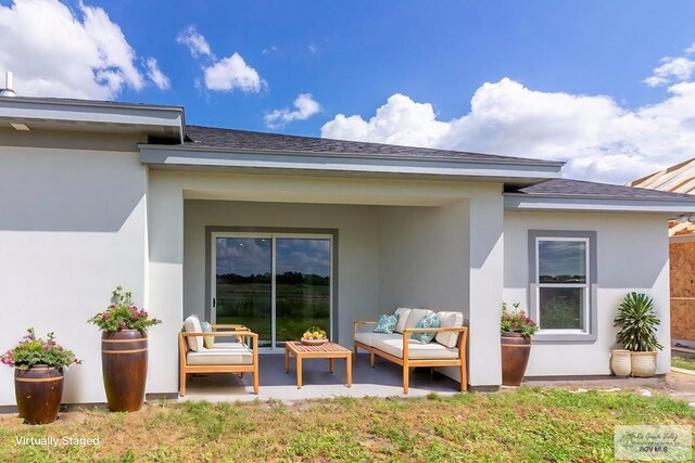 entrance to property with a patio and an outdoor hangout area