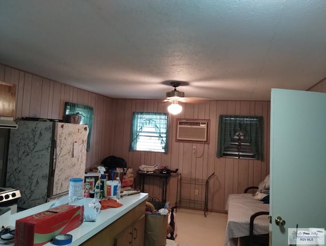 335 Edwards St, San Benito, TX 78586 - kitchen featuring light countertops, a wall mounted AC, ceiling fan, ventilation hood, and refrigerator