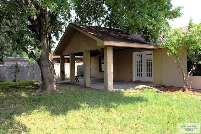 122 Regency Ct, Harlingen, TX 78550 - back of property featuring french doors, a patio area, and roof with shingles