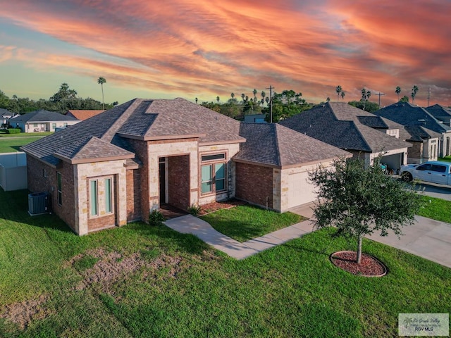 view of front of home featuring a yard and central AC unit