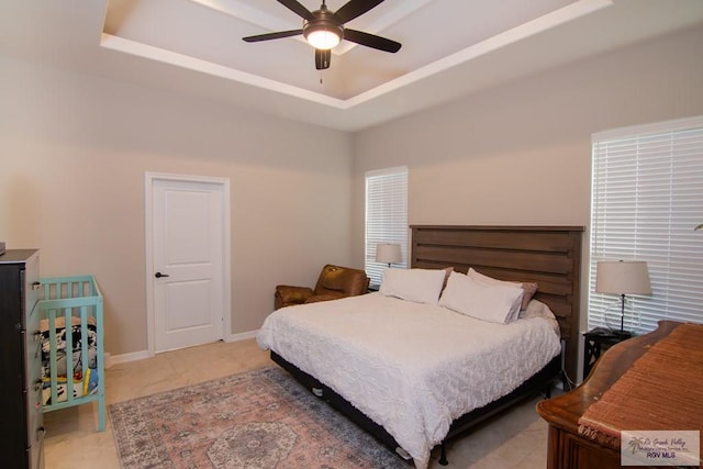 bedroom featuring a raised ceiling and ceiling fan