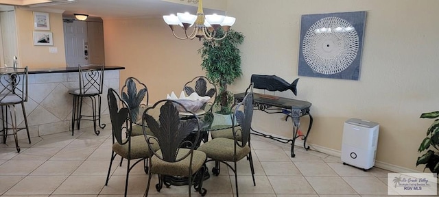 406 Padre Blvd Unit 401, South Padre Island, TX 78597 - dining area with a chandelier, tile patterned floors, and baseboards