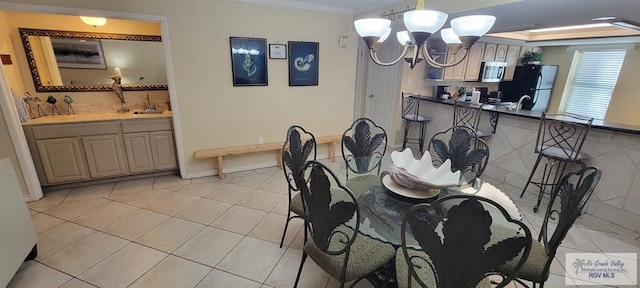 406 Padre Blvd Unit 401, South Padre Island, TX 78597 - dining space featuring a chandelier, ornamental molding, light tile patterned flooring, and baseboards
