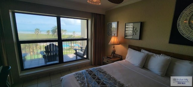 406 Padre Blvd Unit 401, South Padre Island, TX 78597 - bedroom featuring tile patterned flooring, multiple windows, ornamental molding, and a textured wall