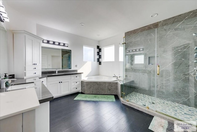 3213 E Westgate Cir, Harlingen, TX 78552 - full bathroom featuring a marble finish shower, a garden tub, two vanities, wood finished floors, and recessed lighting