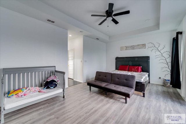 3213 E Westgate Cir, Harlingen, TX 78552 - bedroom with wood finished floors, baseboards, a raised ceiling, and a ceiling fan