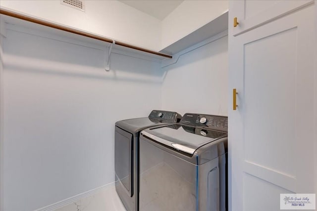 3213 E Westgate Cir, Harlingen, TX 78552 - laundry room with washing machine and clothes dryer, light marble finish flooring, and baseboards