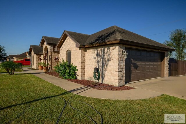 view of front of property featuring a front yard and a garage