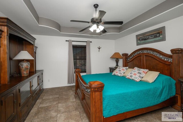 bedroom with ceiling fan and a tray ceiling