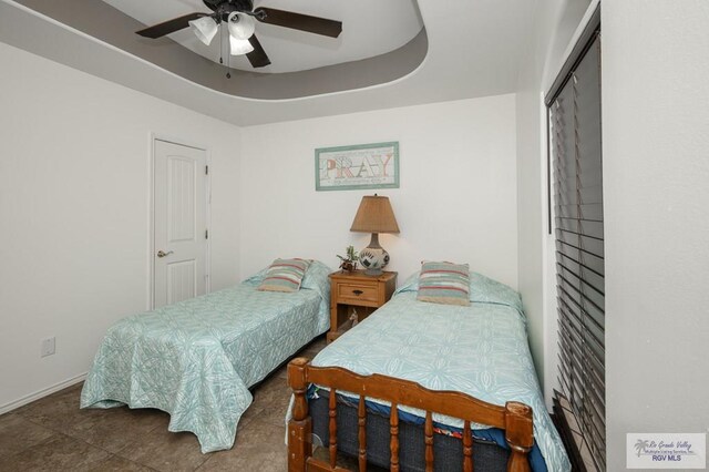 bedroom featuring a closet, a raised ceiling, and ceiling fan