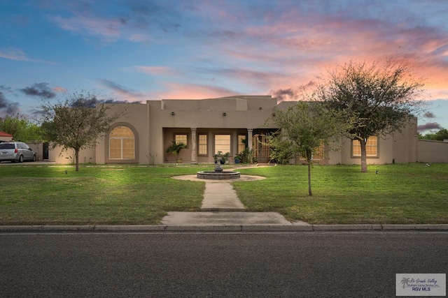 pueblo-style home featuring a yard