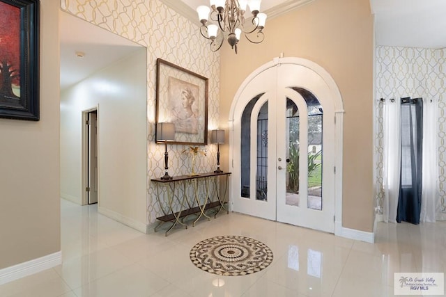 tiled entryway with french doors, an inviting chandelier, crown molding, and a high ceiling