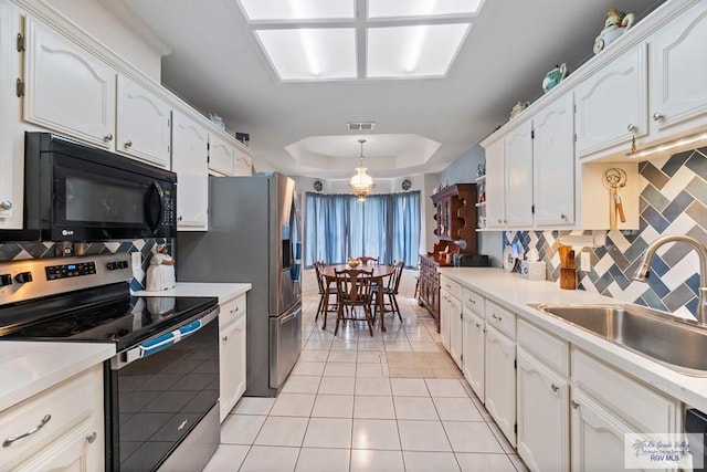 2518 Thomas Ln, Harlingen, TX 78550 - kitchen featuring stainless steel appliances, a sink, white cabinets, a tray ceiling, and backsplash