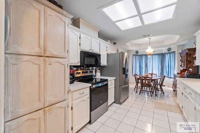 2518 Thomas Ln, Harlingen, TX 78550 - kitchen with stainless steel appliances, a raised ceiling, light tile patterned floors, light countertops, and hanging light fixtures