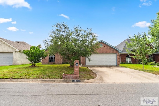 2518 Thomas Ln, Harlingen, TX 78550 - view of front of property with a front lawn, a garage, driveway, and brick siding