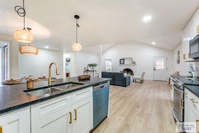 kitchen with stainless steel appliances, decorative light fixtures, sink, and white cabinets