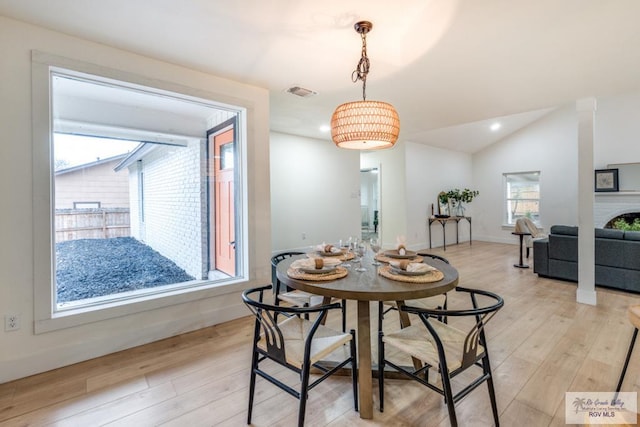 dining area with lofted ceiling and light wood-type flooring