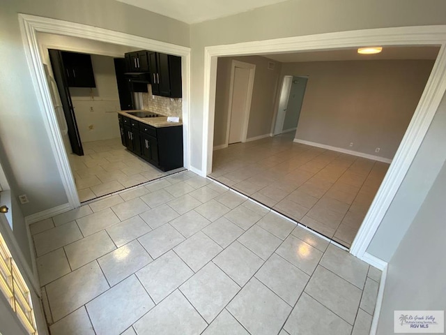 kitchen featuring light tile patterned floors, backsplash, and black electric cooktop