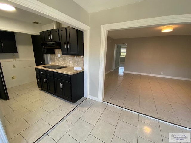 kitchen featuring decorative backsplash, black electric stovetop, and light tile patterned floors