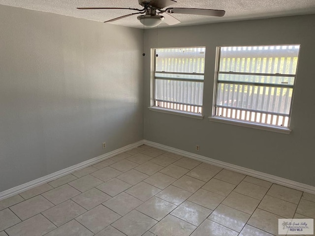 unfurnished room featuring ceiling fan, plenty of natural light, light tile patterned floors, and a textured ceiling