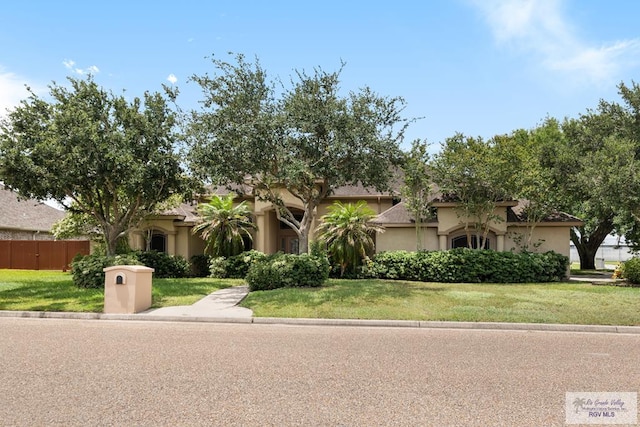 5302 Remington Dr, Harlingen, TX 78552 - view of property hidden behind natural elements with stucco siding and a front lawn