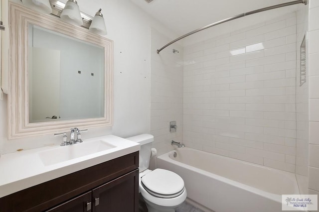 full bathroom featuring vanity, tiled shower / bath combo, and toilet